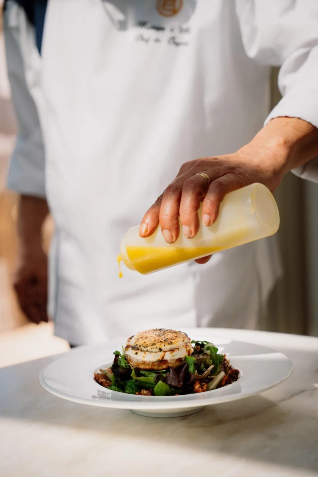 Chefe a temperar salada de queijo de cabra