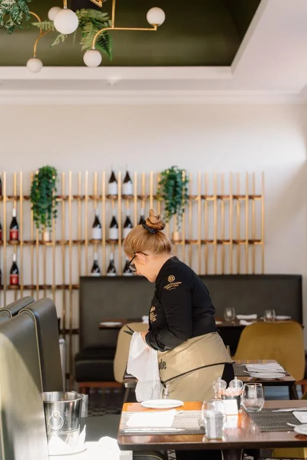 Equipa de sala a preparar uma mesa